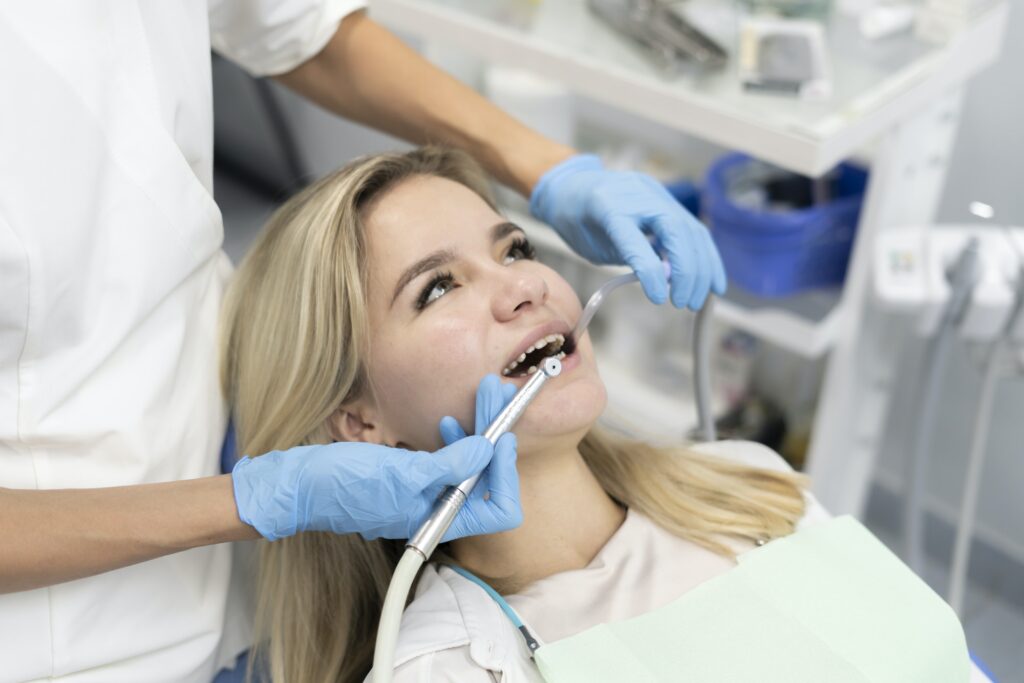 a dentist doctor treats a patient's teeth, uses a drill to drill a tooth